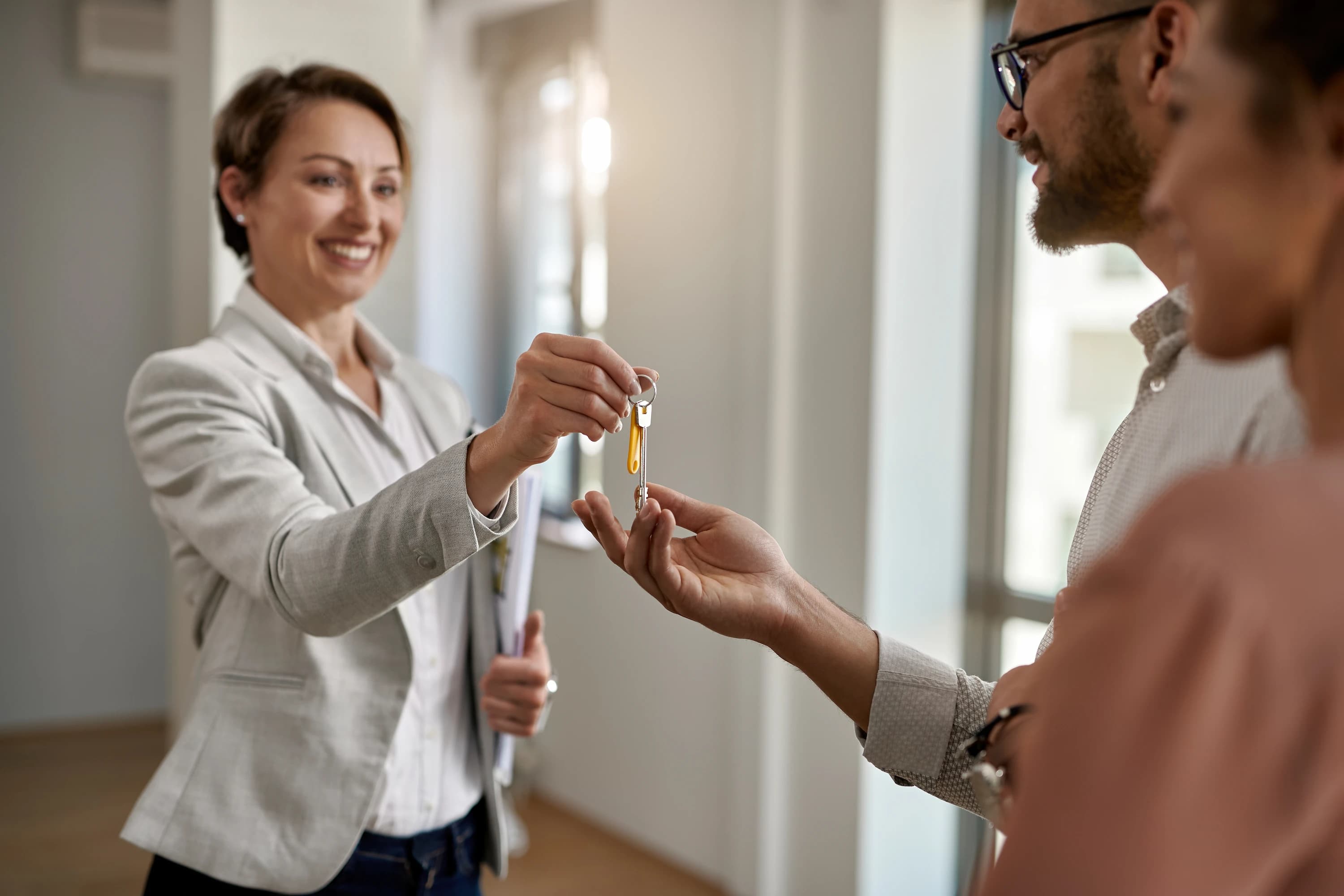 Realitní makléřka předává klíče od bytu novému nájemníkovi